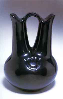 Blackware pottery vessel with tall double-neck. The flawless, polished black surface is reflecting the light/