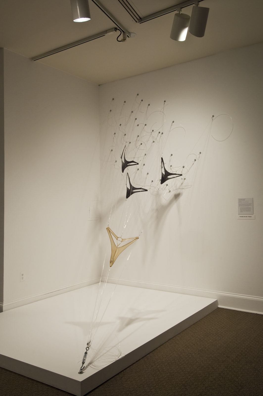 A sculpture made made from spandex and objects resembling military planes flying down towards the ground.