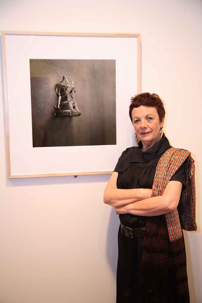 A woman standing in front of a black and white photograph.