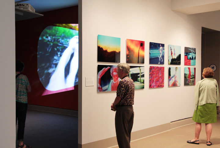 NMWA members looking at Rist's video installation and a series of her prints on Member Preview Day; Photo Laura Hoffman