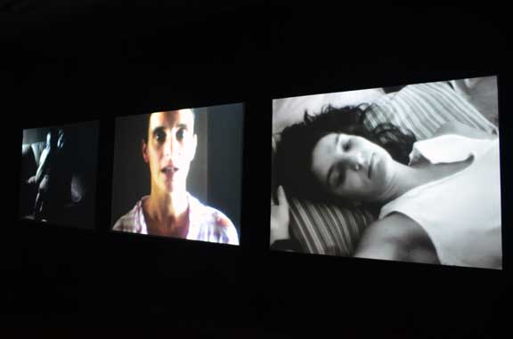 Installation view of three screens showing films.