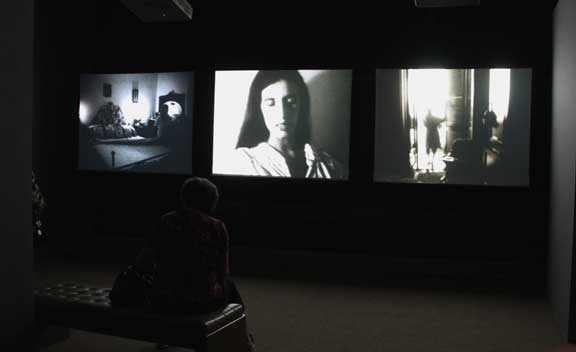 Installation view of three screens next to each other showing different films.