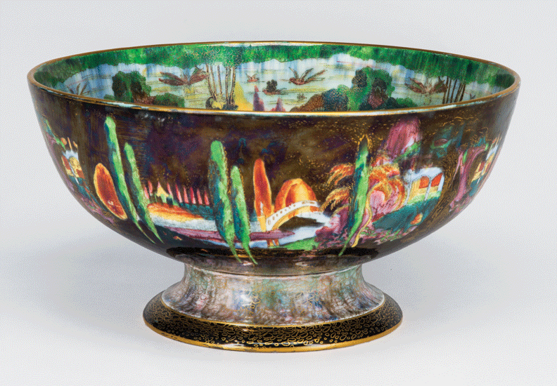 Porcelain pedestal bowl featuring an iridescent lustreware glaze. Around the bowl, trees on a vibrant dark background. The decorative elements along the rim and foot of the bowl are outlined in gold cloisonne.