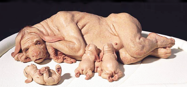 A sculpture of a naked creature who has human body and a pig head breast feeding two babies that look similar. There is one more baby on the left lying on its back.