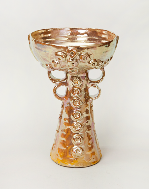 A golden chalice with ornaments. The chalice is shimmering and delicate.
