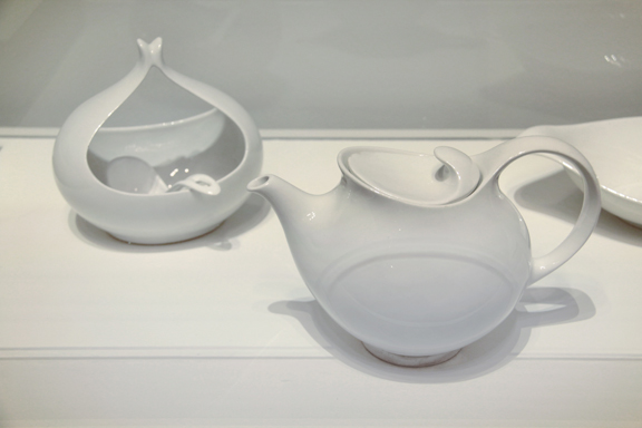 A ceramic teapot and sugar bowl in white. They have an usual, organic shape.