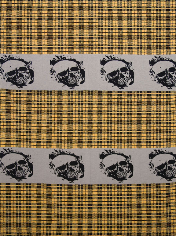 An art piece made of fabric shows several skulls on an orange checkered background. The skulls are repeating themselves and have a knitted texture.