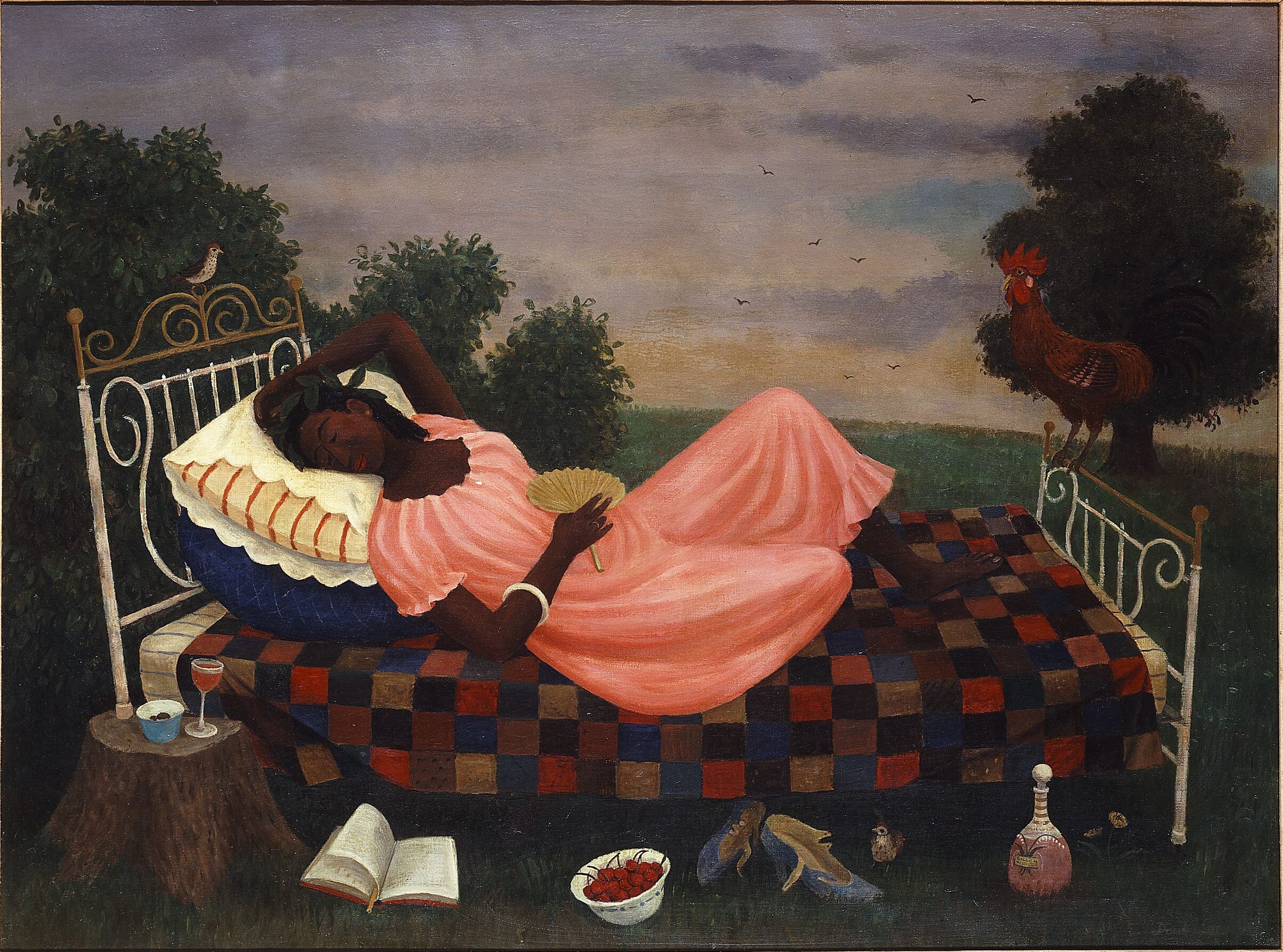 Outdoors, a dark-skinned woman in a peach dress reclines on a bed, a bird perches on the headboard and a rooster on the footboard. In the foreground, a wine glass and bowl sit on a tree stump, and an open book, bowl of cherries, pair of shoes and a wine bottle sit on the grass.