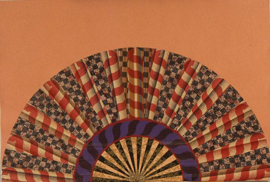 A colorfully painted and collaged folding fan spread open on a peach-orange background.