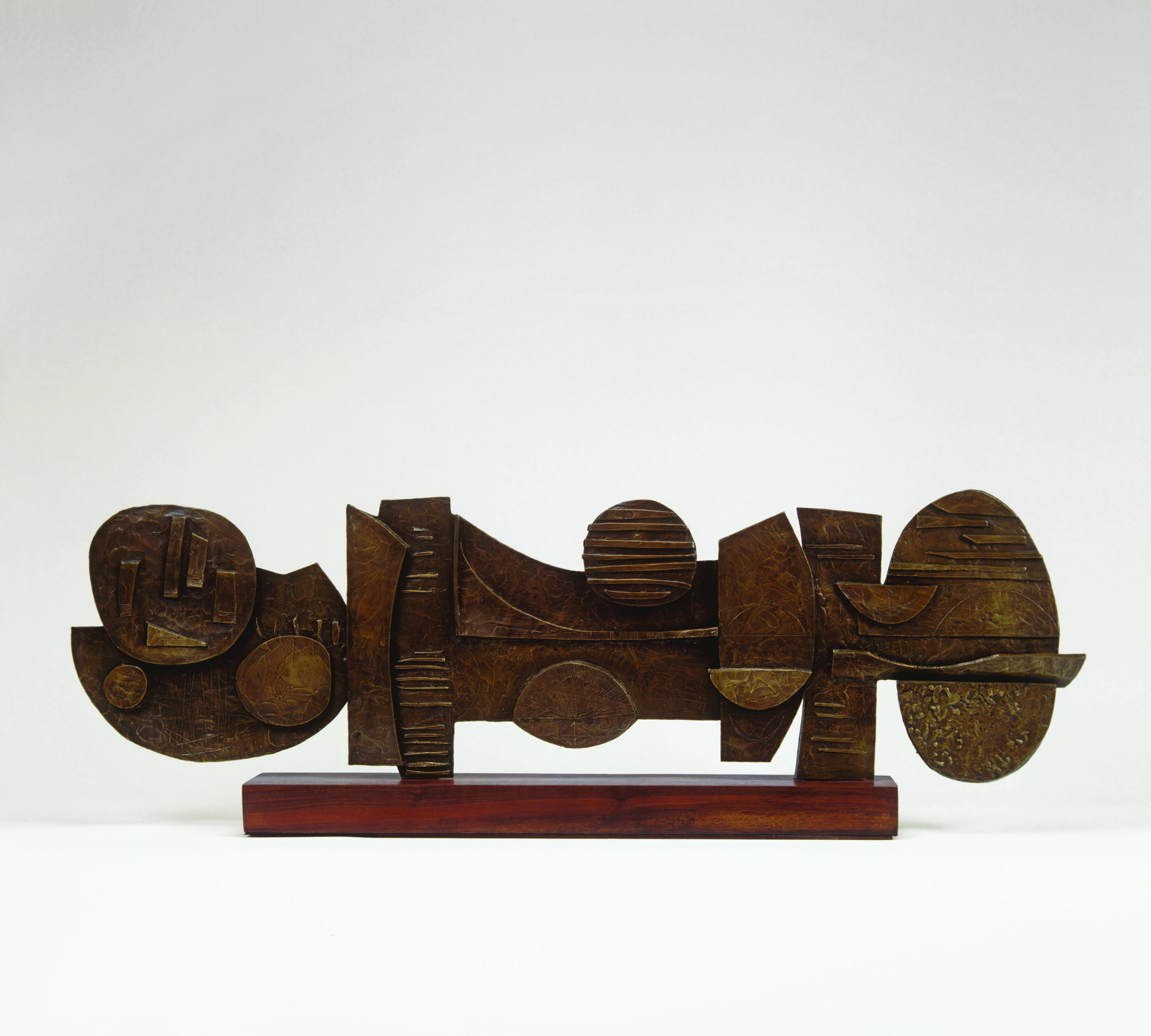 Bronze sculpture with a rich, golden patina set on a wood base. The horizontal composition is comprised of geometric shapes of overlapping disks, ovals, and rectangles, some enhanced by textures.