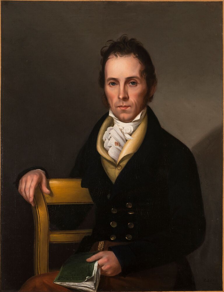 Side-by-side portraits of a husband and wife with light skin tone and dark hair sitting in formal postures. Gazing outward, they wear dark clothing with light accents and the woman wears a gold earring and pin. They both hold objects: the woman a brocaded red cloth and the man a book.