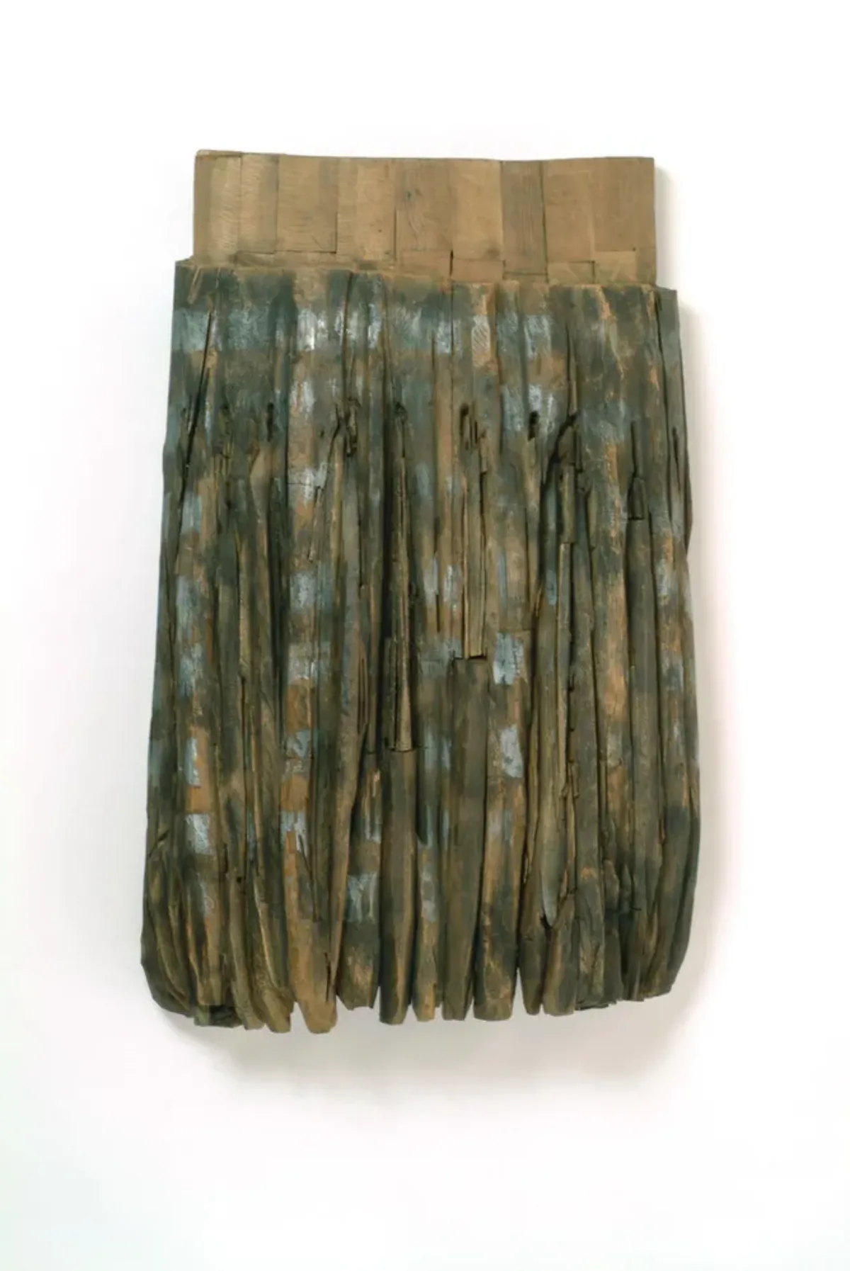 Resembling the pleats and band of an apron, this large, one-sided, cedar sculpture features carved vertical lines darkened with graphite and stain beneath a solid band of natural-colored wood.