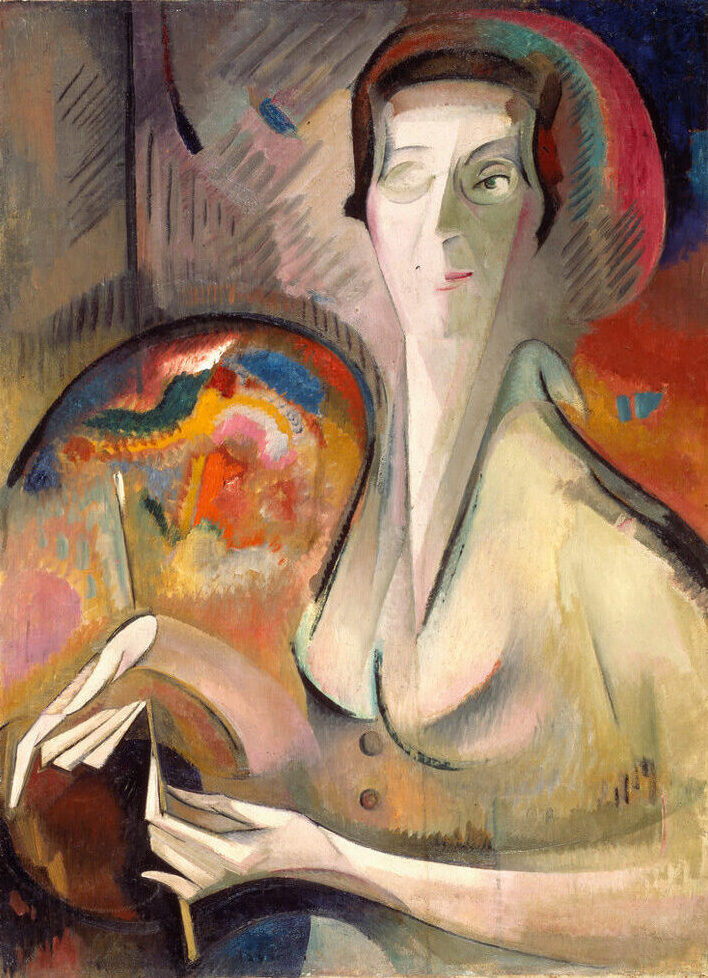 Dynamic painting features a backdrop of red, orange, and blue hues. The artist's face, hands, and body are composed of conjoined geometric and organic shapes in a neutral color palette. Her left eye and hands are explicitly described, as is artist's palette on her right.