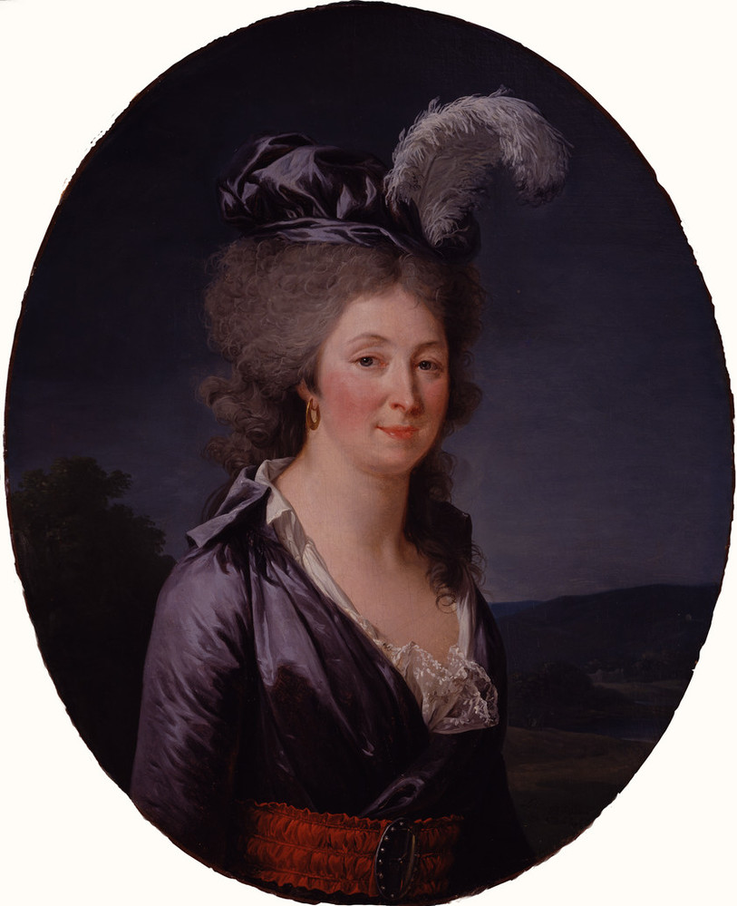 A light-skinned woman with grey hair stands in front of a dark landscape. She smiles slightly, wearing a blue dress with long sleeves, white lace, and a brown belt with a dark buckle. A large white feather perches on her blue hat, a gold earring hangs from her right ear.