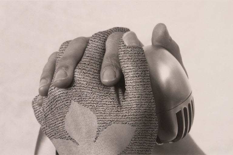 Close-up, black-and-white photograph of a woman's hands with fingers interlaced around a silver, vintage microphone. Lines of poetry inscribed in Farsi form a three-leaf shape on her left hand.
