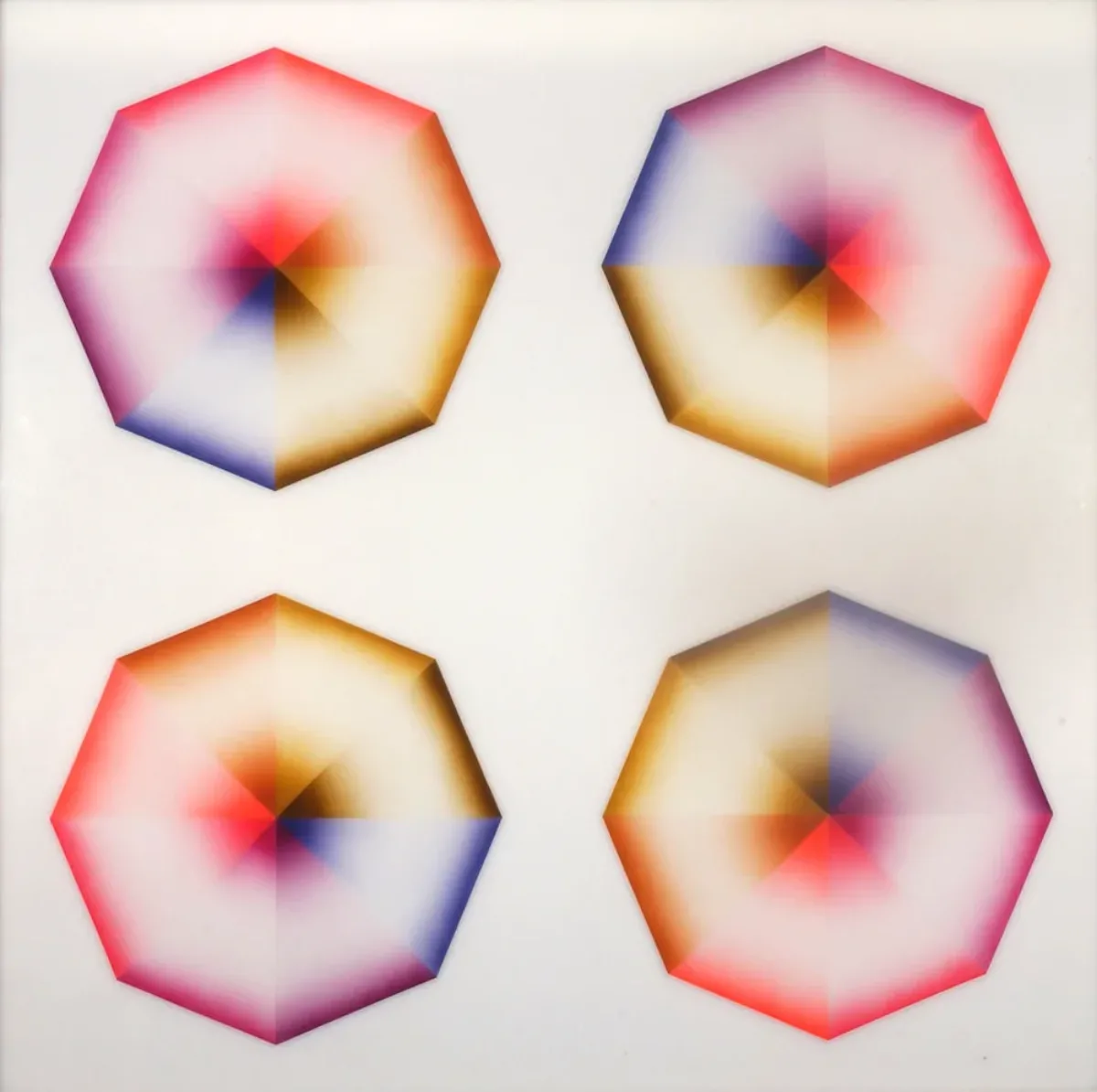 Four hard-edged octagons, each divided into eight pie-slice shapes painted red, pink, orange, yellow, olive green, blue, violet, or lavender, occupy a square, white background. Dark at the wide and narrow ends of each wedge, the hues create the illusion of 3-dimensional forms.