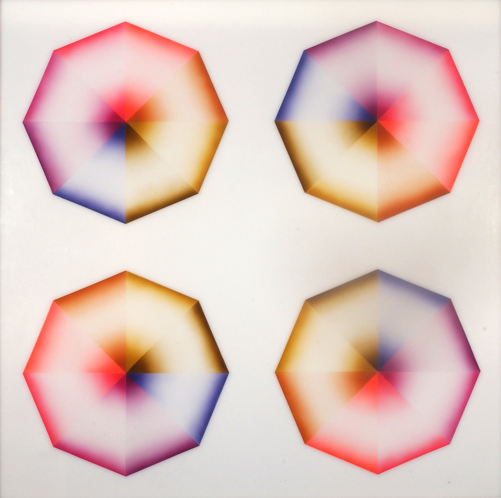 Four hard-edged octagons, each divided into eight pie-slice shapes painted red, pink, orange, yellow, olive green, blue, violet, or lavender, occupy a square, white background. Dark at the wide and narrow ends of each wedge, the hues create the illusion of 3-dimensional forms.