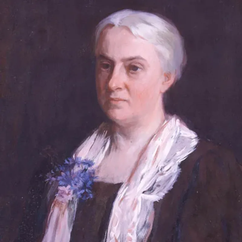 A painted portrait of a light-skinned older woman with white hair pulled back from her face. She is portrayed from the waist up against a dark background. She wears a black dress with a white sash. A bouquet of blue flowers decorates the left side of the sash. She gazes left of the frame.