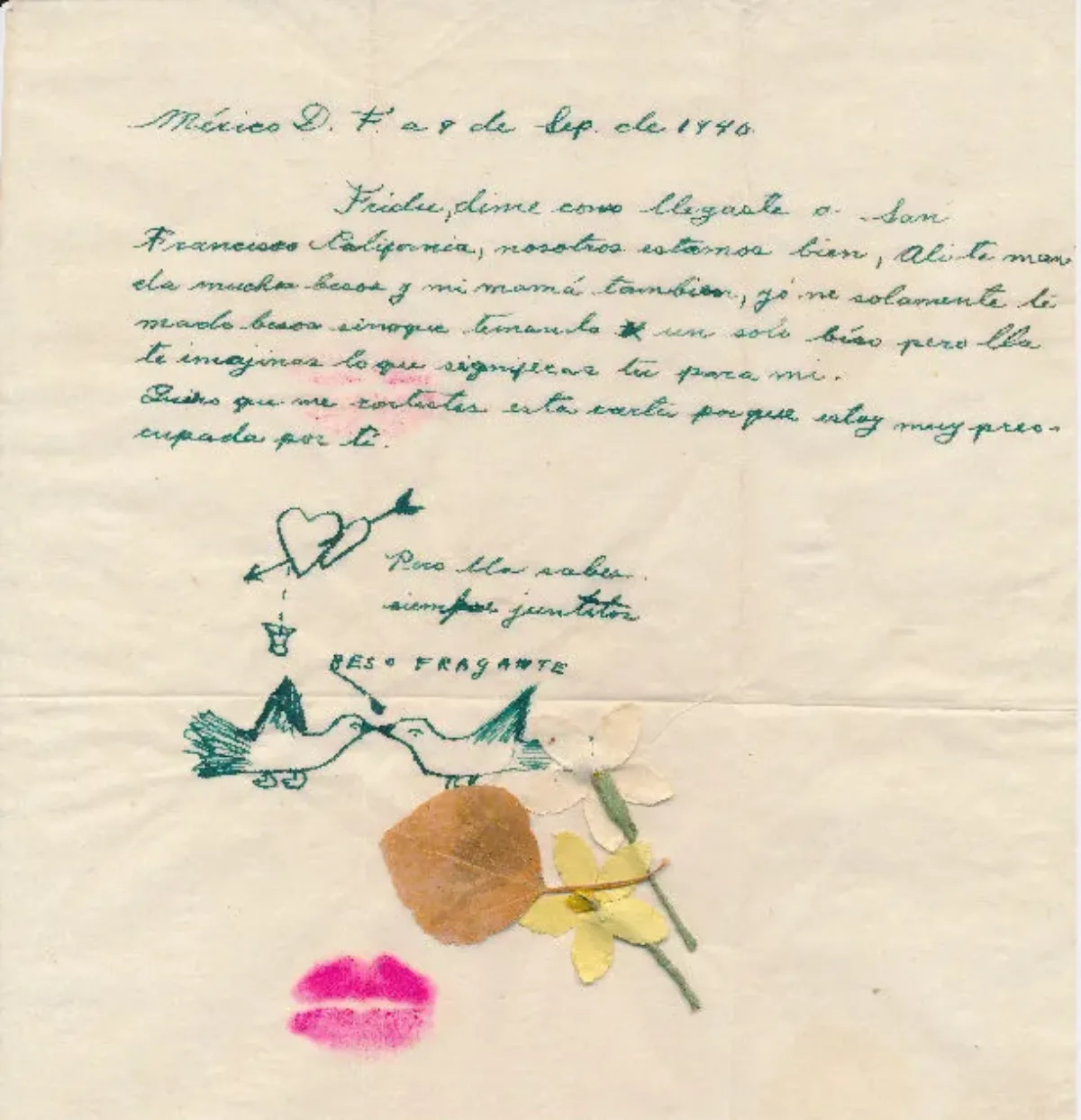 A brief note, handwritten in Spanish in green ink on yellowed paper, dated September 9, 1940. Beneath the closing, drawings of two hearts connected by an arrow and two birds beak to beak, along with two collaged flowers and a leaf, and a bright pink lipstick imprint.