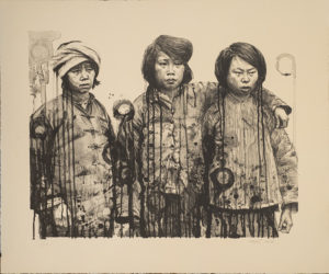 Three you women stand together with arms around each other. They are wearing military uniforms.