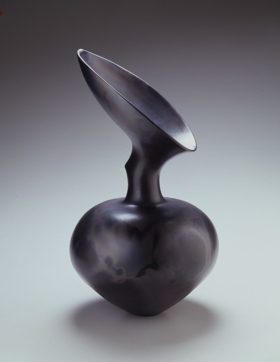 Black earthenware vase with bulb-shaped bottom, thin neck, and an angled funnel top.