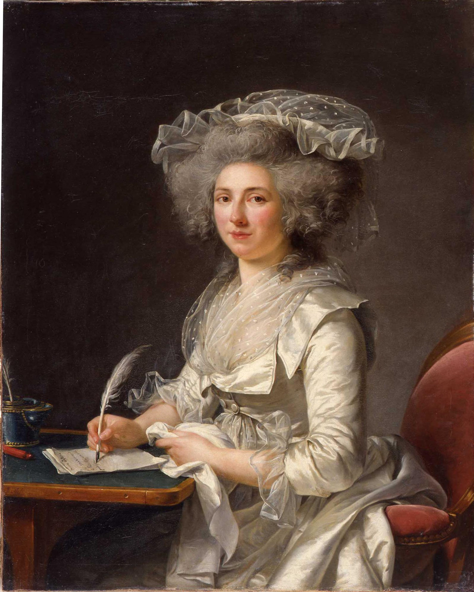 A portait of a woman dressed in fine ivory silks sitting at a writing desk grasping a feather quill pen in her right hand. She gazes out towards the viewer and her skin is a pale, pinkish hue, with a baroque hairstyle and tulle bonnet.