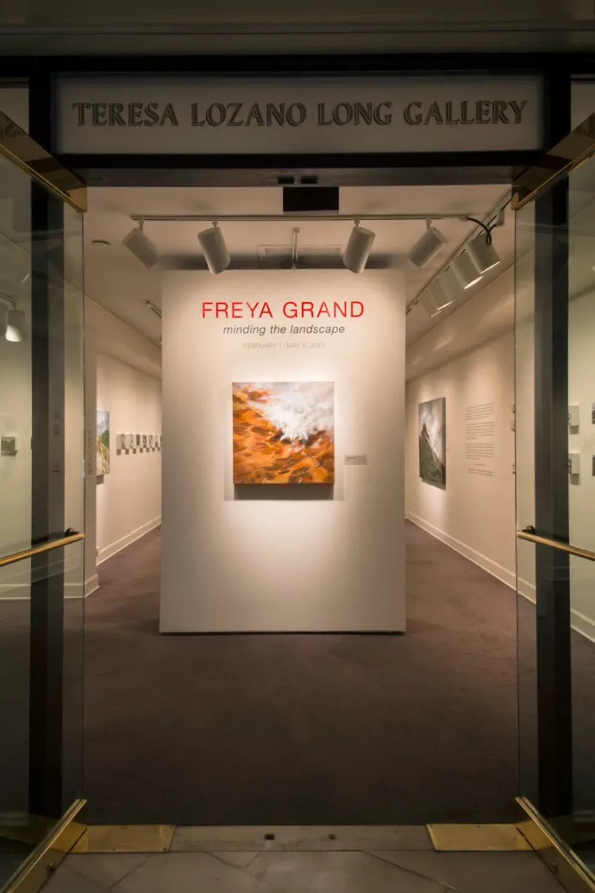 A view into a small gallery with a painting affixed to a temporary wall in the middle of the gallery.