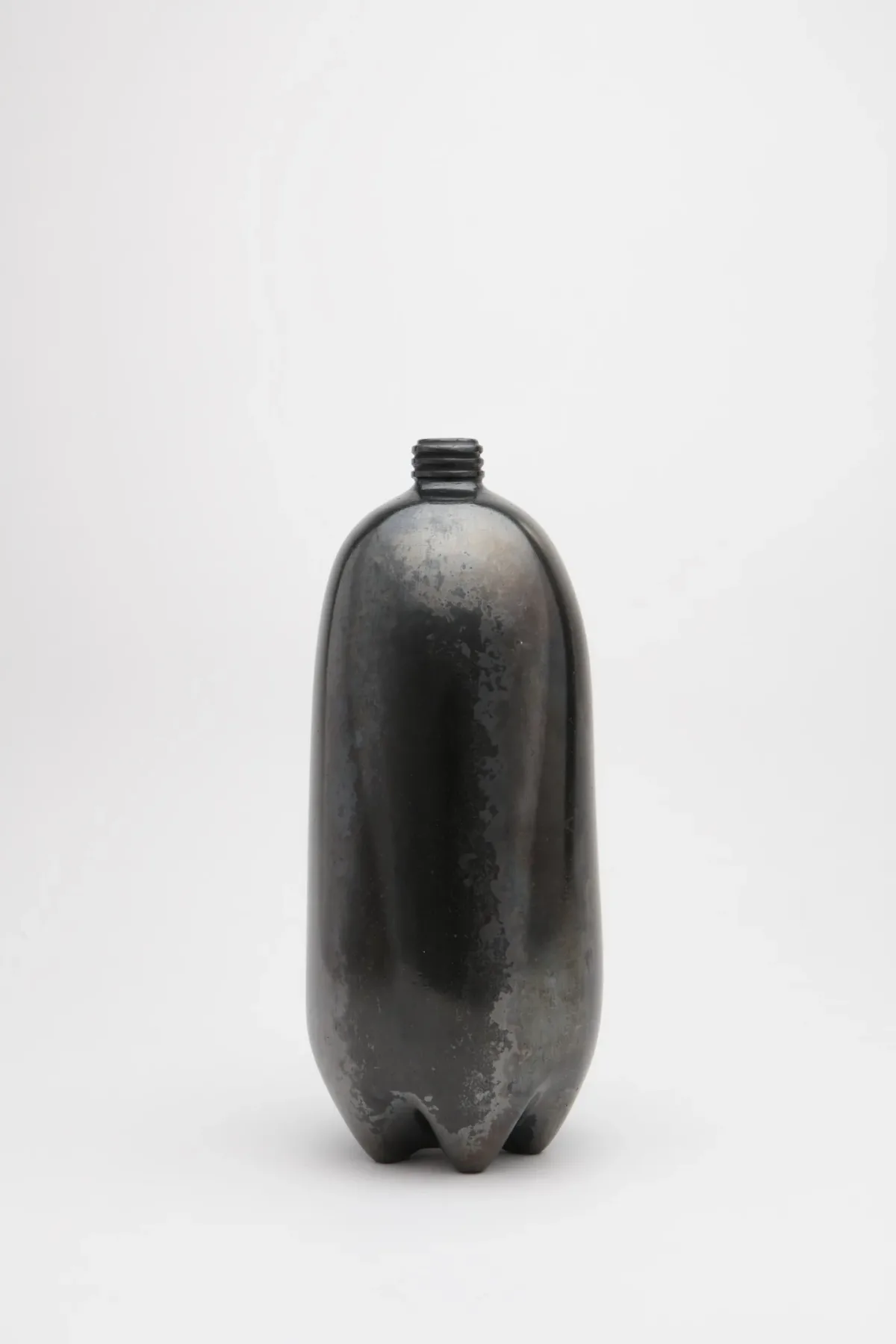 Shiny, black clay sculpture resembling a two-liter plastic bottle.