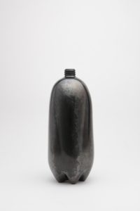 Shiny, black clay sculpture resembling a two-liter plastic bottle.
