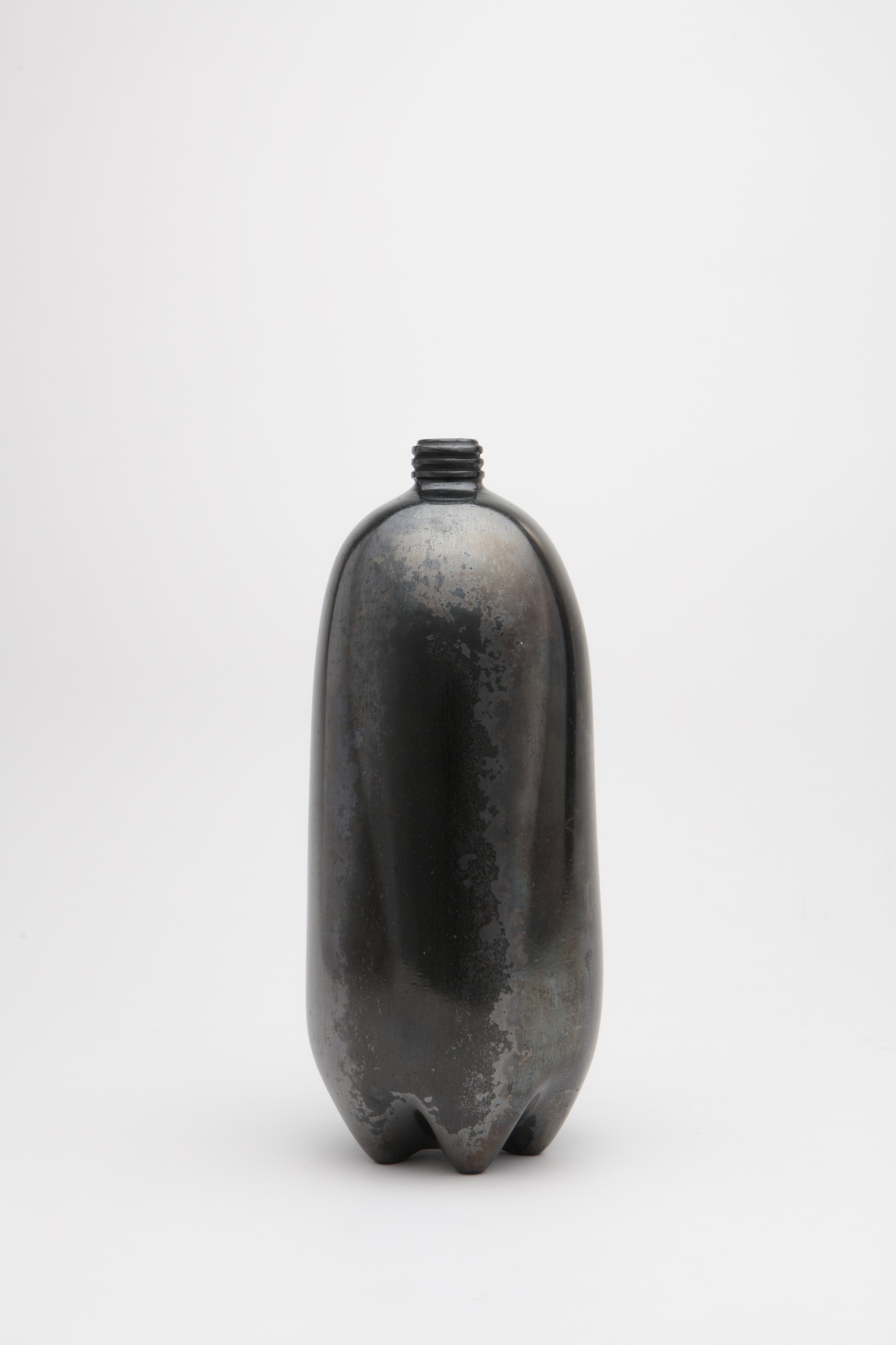 Shiny, black clay sculpture resembling a two-liter plastic bottle.