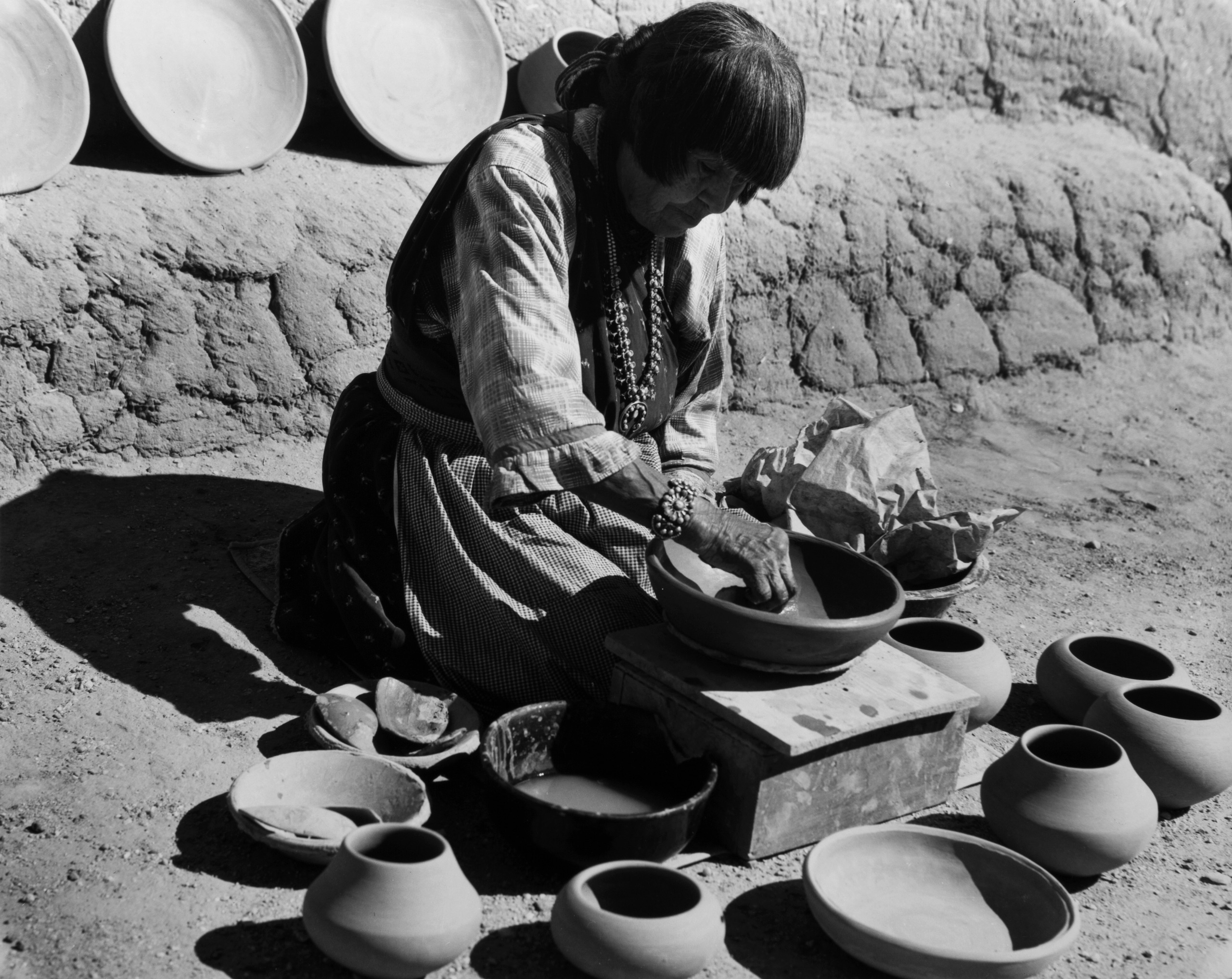 Black and white photograph of woman with medium skin tone making pottery.