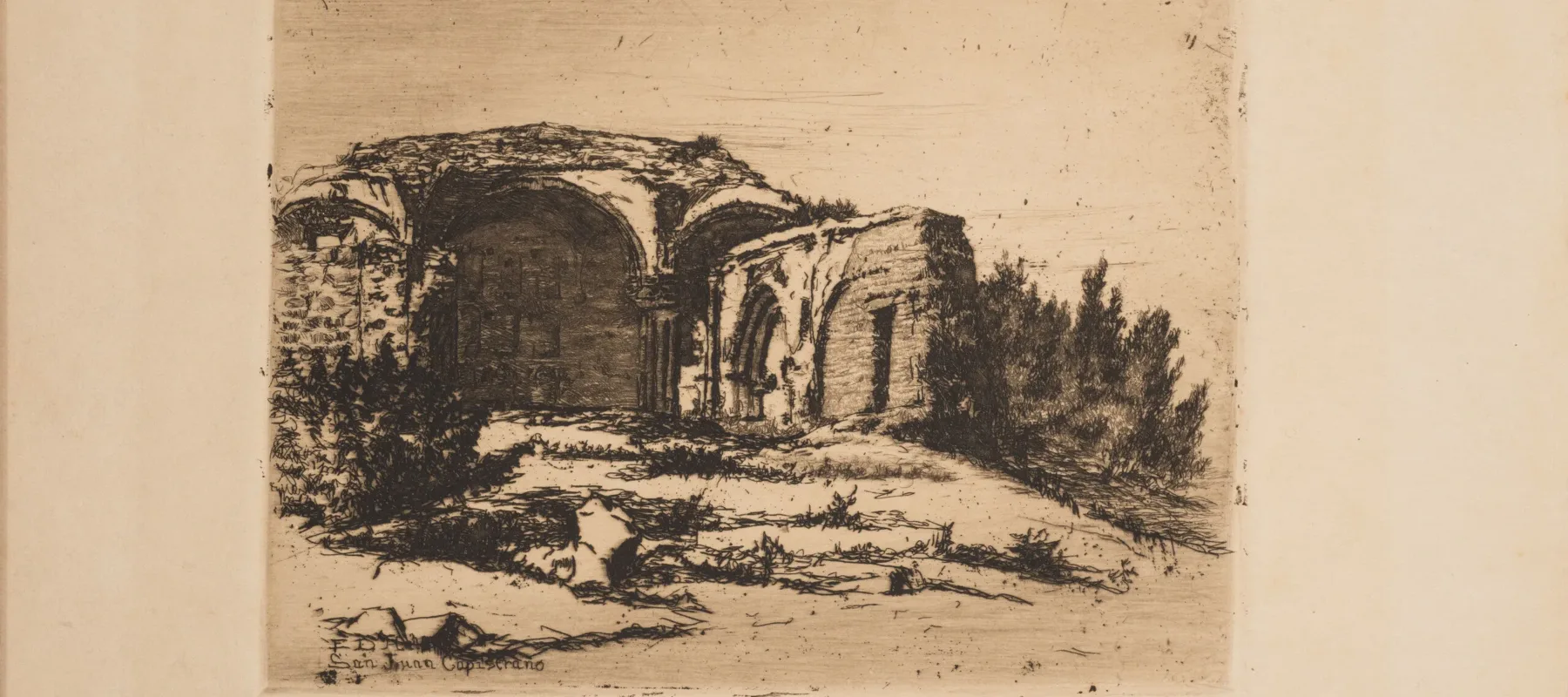 Small print of black ink on ecru paper depicting the ruins of an old Catholic mission building. The building, featuring rounded arches, crumbling facades, and exposed brick, is surrounded by scrub bushes and desert landscape.