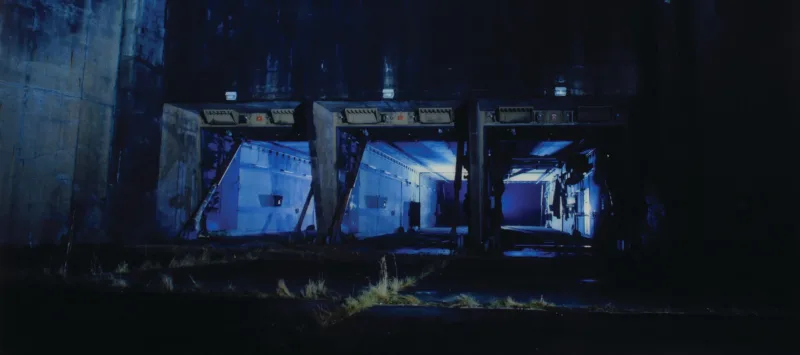 Eery photograph in blue tones of a concrete silo at night.