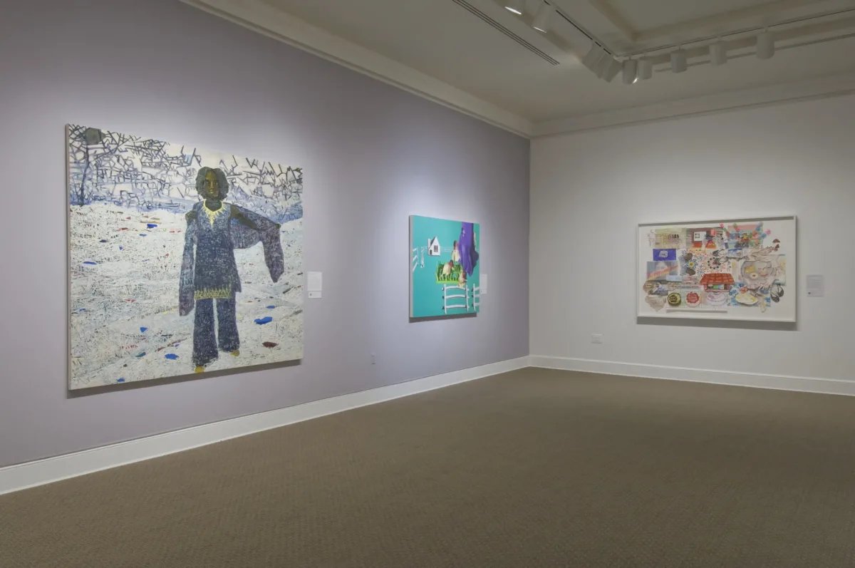 Two large paintings hang on a lavender wall. In the first, a dark-skinned woman stands in a white landscape, and in the other, a fence, house, and large birds float on a solid turquoise background. On the other white wall is an abstract multimedia work with houses, cakes, and patterns.