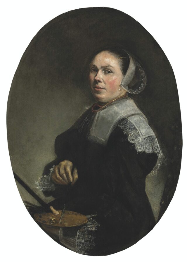 Portrait of a woman wearing dark clothing and a white bonnet sitting at an easel with paintbrushes in her hand. She is looking directly at the viewer.