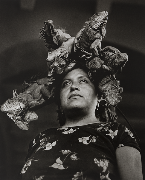 A black-and-white portrait photograph of a woman with a medium-light skin tone wearing a crown made out of iguanas.