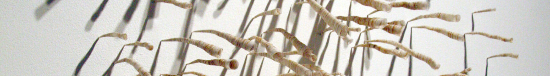 Close up view of an array of cylindrical fiber pieces attached to a wall.