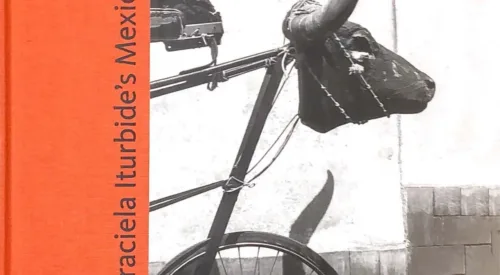 Cover of the exhibition catalogue titled 'Gracieal Iturbide's Mexico' shows a black and white photo of the front of a bicycle with an animal scull and horns in place of handlebars.