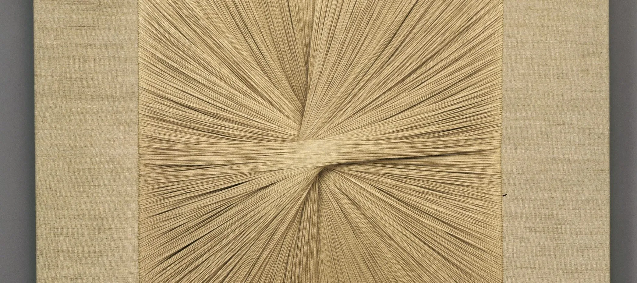 Square textile panel uses beige thread to create a starburst pattern as the central focus.