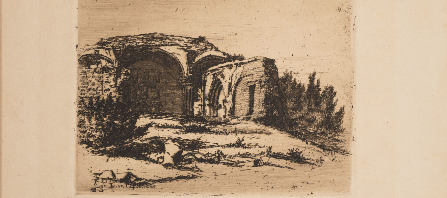 Small print of black ink on ecru paper depicting the ruins of an old Catholic mission building. The building, featuring rounded arches, crumbling facades, and exposed brick, is surrounded by scrub bushes and desert landscape.