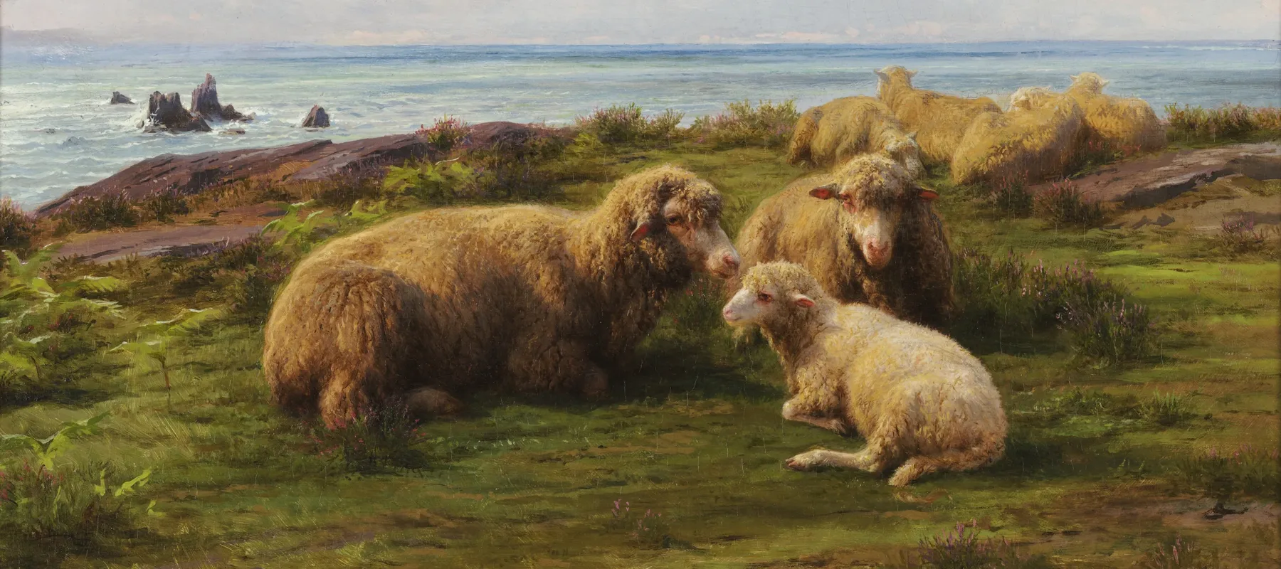 A flock of sheep rest on a green hill by the sea. In the center, two adults and a lamb lie in a group. Flat rocks are visible through the grass. The sky has rolling clouds, and a breeze is suggested by the waves crashing on rocks in the sea, which stretches to the horizon.