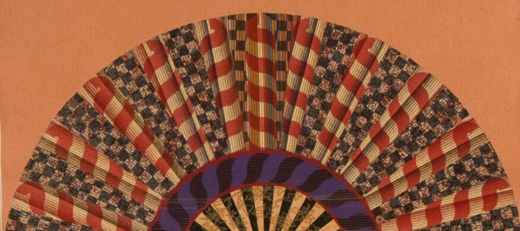 A colorfully painted and collaged folding fan spread open on a peach-orange background.