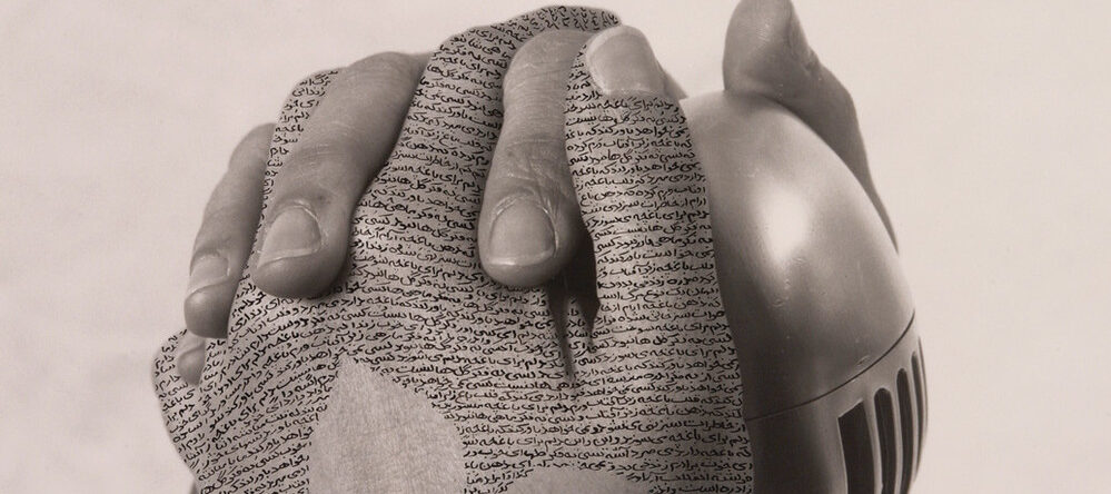 Close-up, black-and-white photograph of a woman's hands with fingers interlaced around a silver, vintage microphone. Lines of poetry inscribed in Farsi form a three-leaf shape on her left hand.
