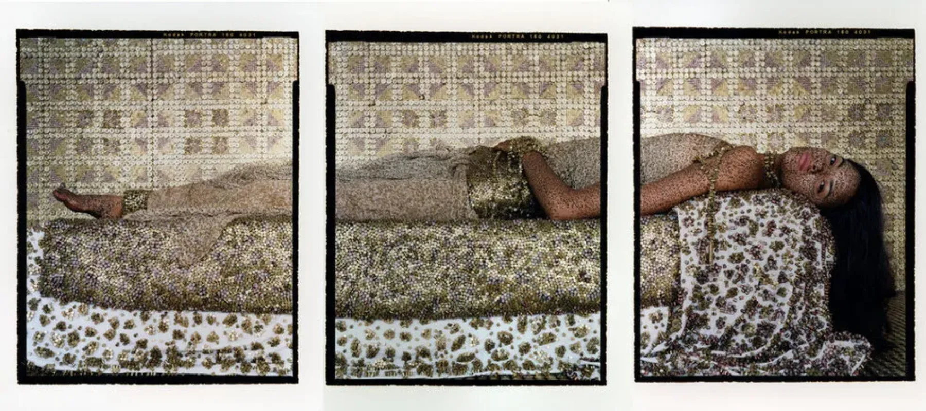 Three photographs join to show a woman lying on a bed on her back. Turning her head to look at the viewer, she wears airy light clothing and a heavy, wide gold belt and her long hair falls to the floor. A metallic surface covers everything—the walls, furniture and the woman.