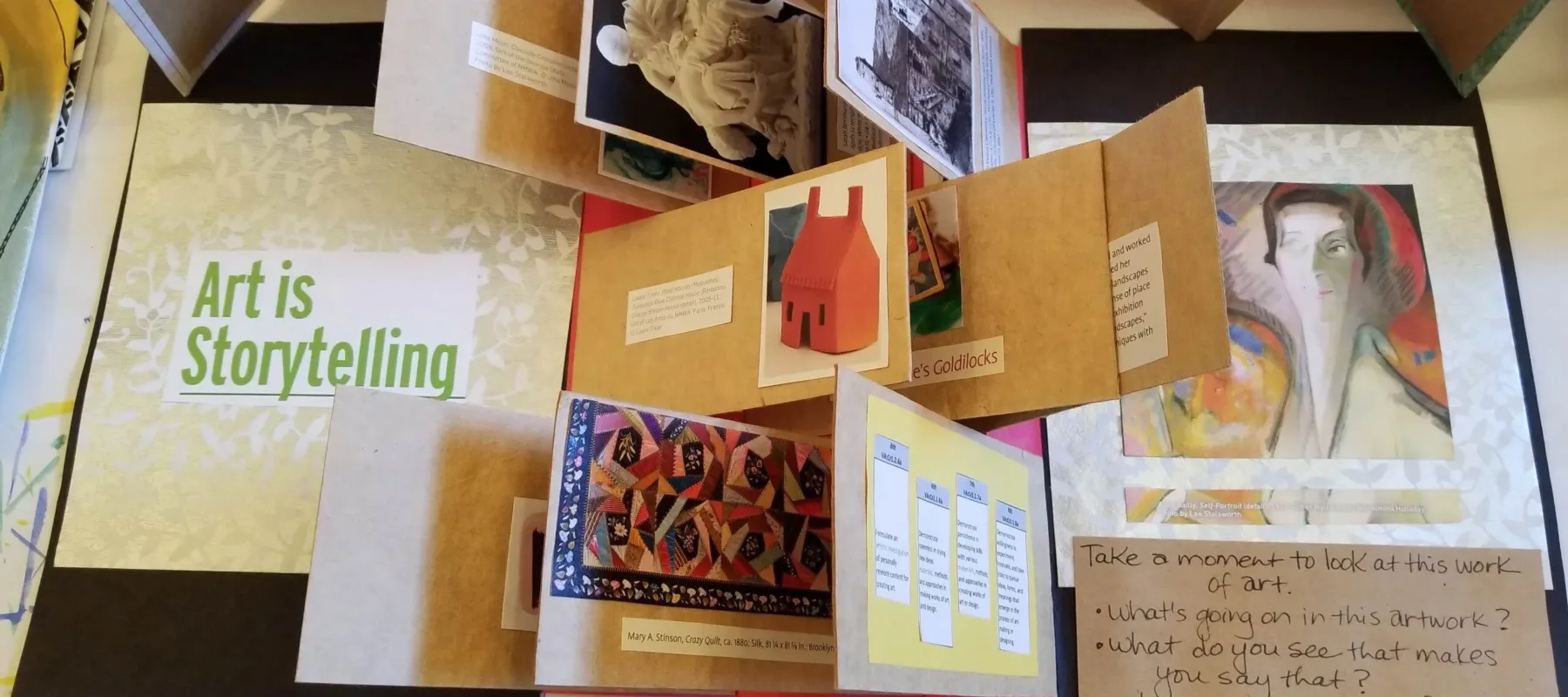 A birds-eyed view of a variety of artists books showing a variety of folded paper and works of art.