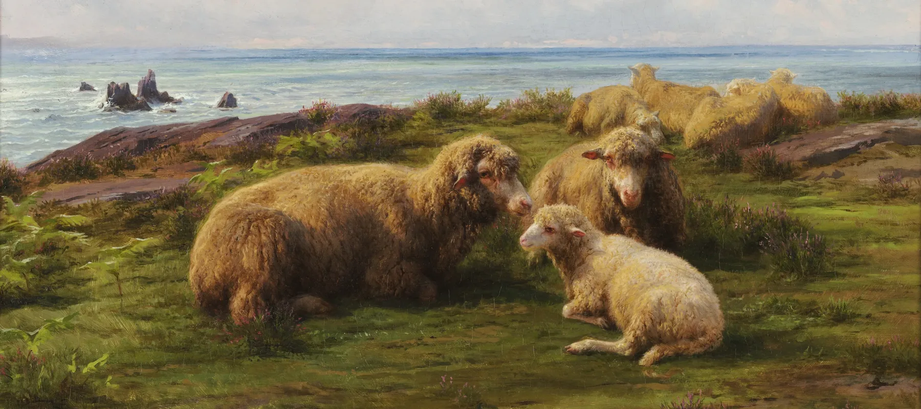 A flock of sheep rest on a green hill by the sea. In the center, two adults and a lamb lie in a group. Flat rocks are visible through the grass. The sky has rolling clouds, and a breeze is suggested by the waves crashing on rocks in the sea, which stretches to the horizon.