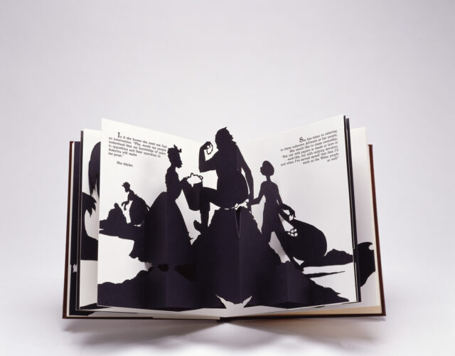 Four black silhouetted figures emerge from the white, open pages of a pop-up book. They appear to be engaged in manual labor. Two of the figures wear full floor-length skirts.