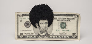 U.S. five-dollar bill has an embroidered afro and sideburns stitched onto the portrait of Lincoln’s head. One-third of the afro protrudes beyond the top of the bill.