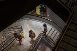 Photo looking down through a spiral staircase of the museum; three young adults are making their way up the stairs.