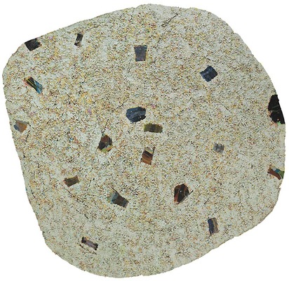 A round shape in beige with small geometric shapes cut out and a rough texture evoking a rocky surface or sand.